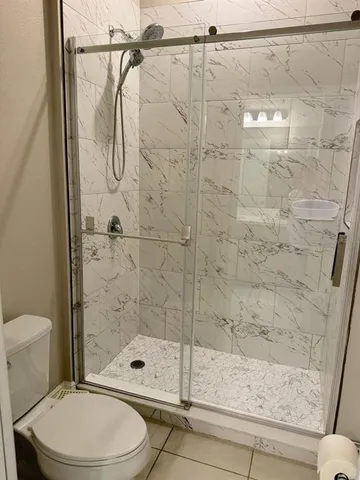 a bathroom with a shower a toilet and a shower
