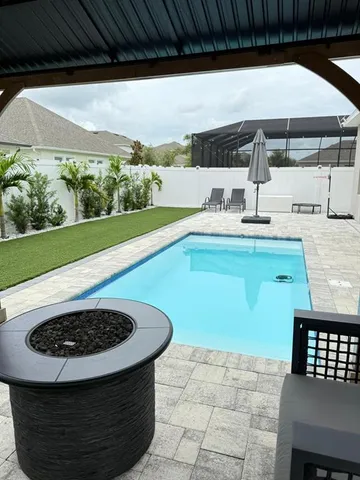 a view of swimming pool with outdoor seating and plants