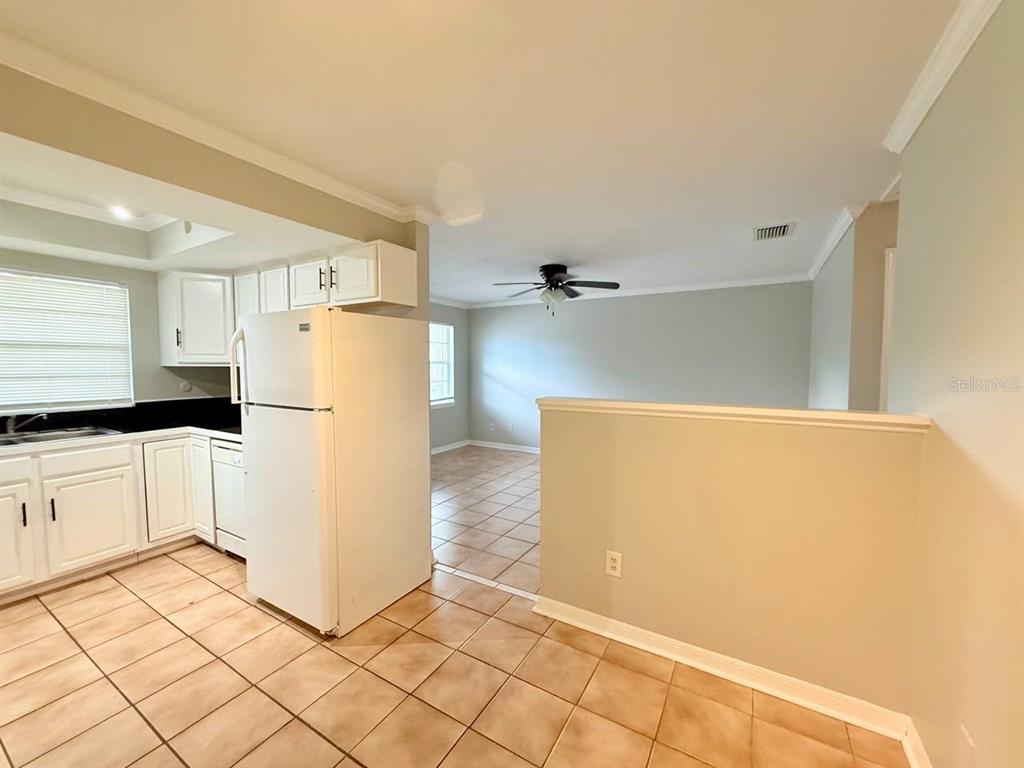 727 Milwaukee Avenue, Unit 6 Dunedin, FL 34698 - Photo 11 of 18 a kitchen with a refrigerator a stove top oven and white cabinets