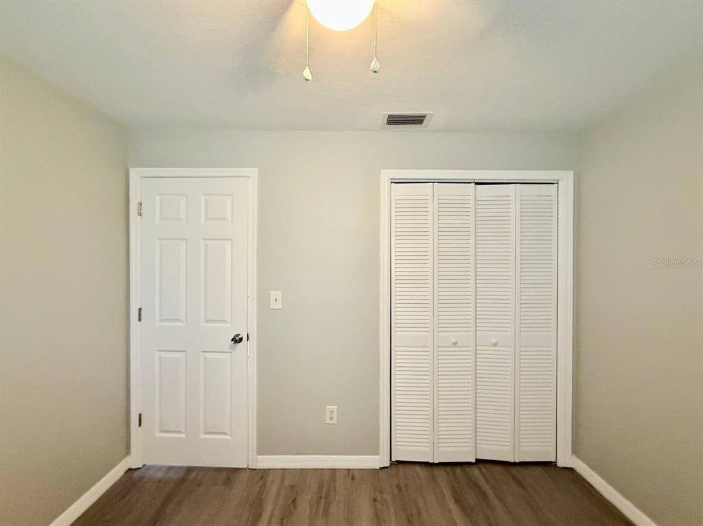 727 Milwaukee Avenue, Unit 6 Dunedin, FL 34698 - Photo 14 of 18 an empty room with wooden floor and closet area
