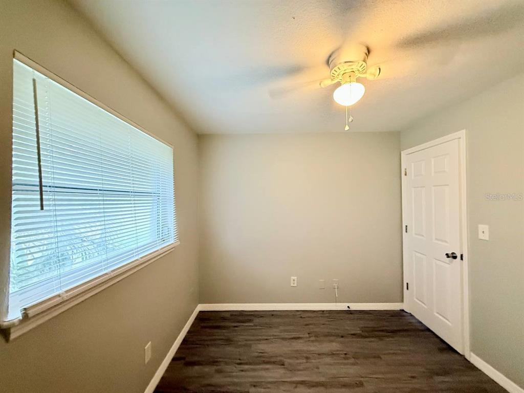 727 Milwaukee Avenue, Unit 6 Dunedin, FL 34698 - Photo 15 of 18 a view of an empty room with wooden floor and a window