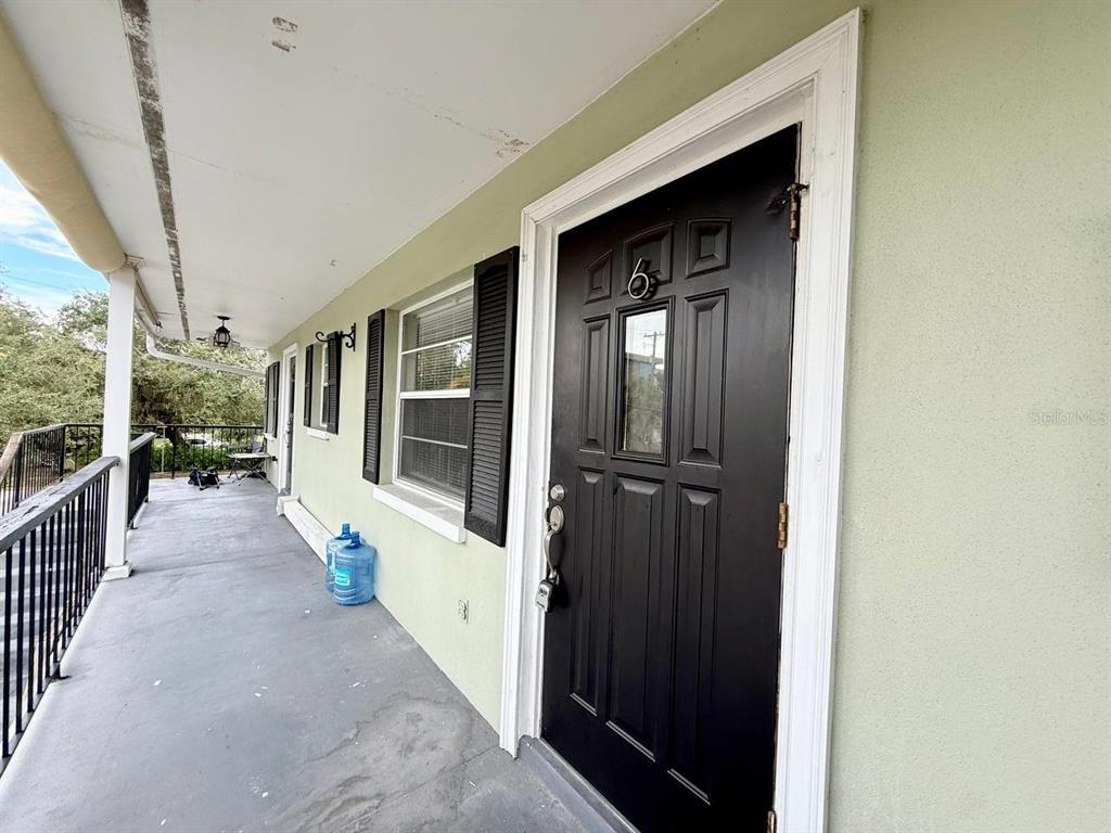 727 Milwaukee Avenue, Unit 6 Dunedin, FL 34698 - Photo 2 of 18 a view of a porch with wooden floor and stairs