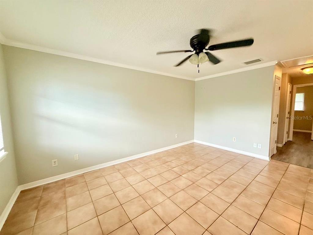 727 Milwaukee Avenue, Unit 6 Dunedin, FL 34698 - Photo 8 of 18 a view of a room with a ceiling fan and wooden floor