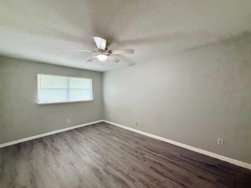 727 Milwaukee Avenue, Unit 6 Dunedin, FL 34698 - Photo 9 of 18 wooden floor in an empty room with a window