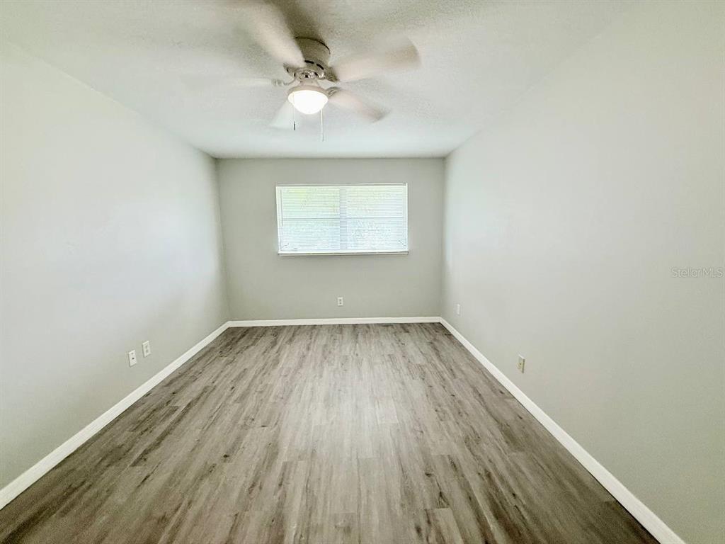 727 Milwaukee Avenue, Unit 6 Dunedin, FL 34698 - Photo 10 of 18 an empty room with wooden floor and windows