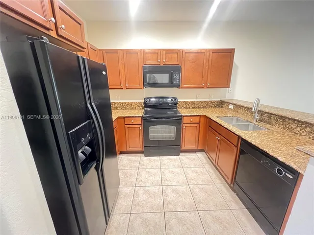 a kitchen with stainless steel appliances granite countertop a refrigerator stove and sink
