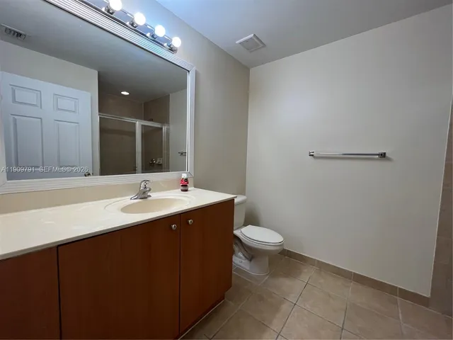 a bathroom with a toilet a sink and mirror