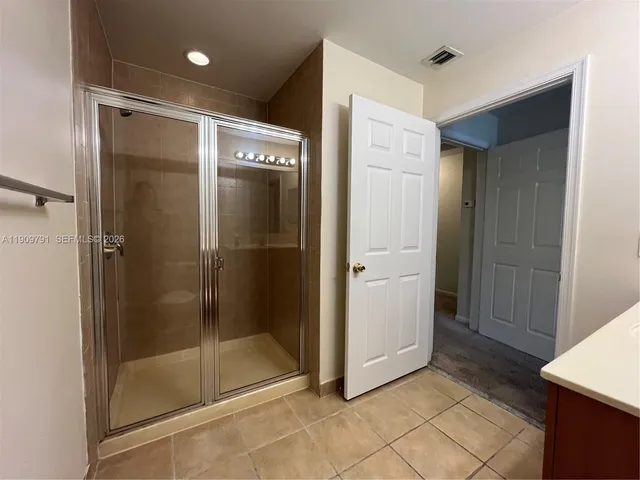 a bathroom with a shower and a glass door