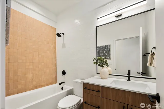 a bathroom with a tub sink toilet and mirror