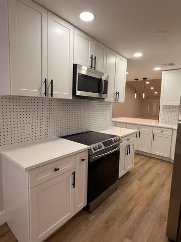 a kitchen with stainless steel appliances granite countertop a sink a stove and cabinets