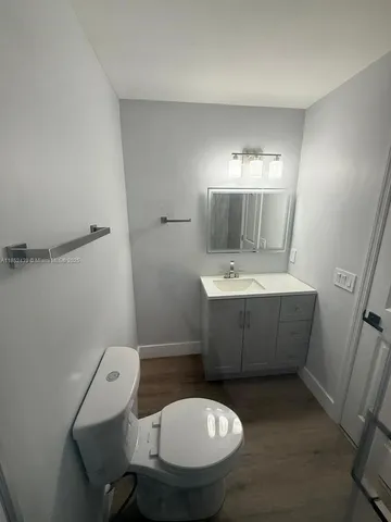 a bathroom with a toilet a sink and mirror