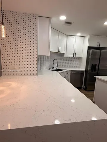 a kitchen with a sink a refrigerator and cabinets