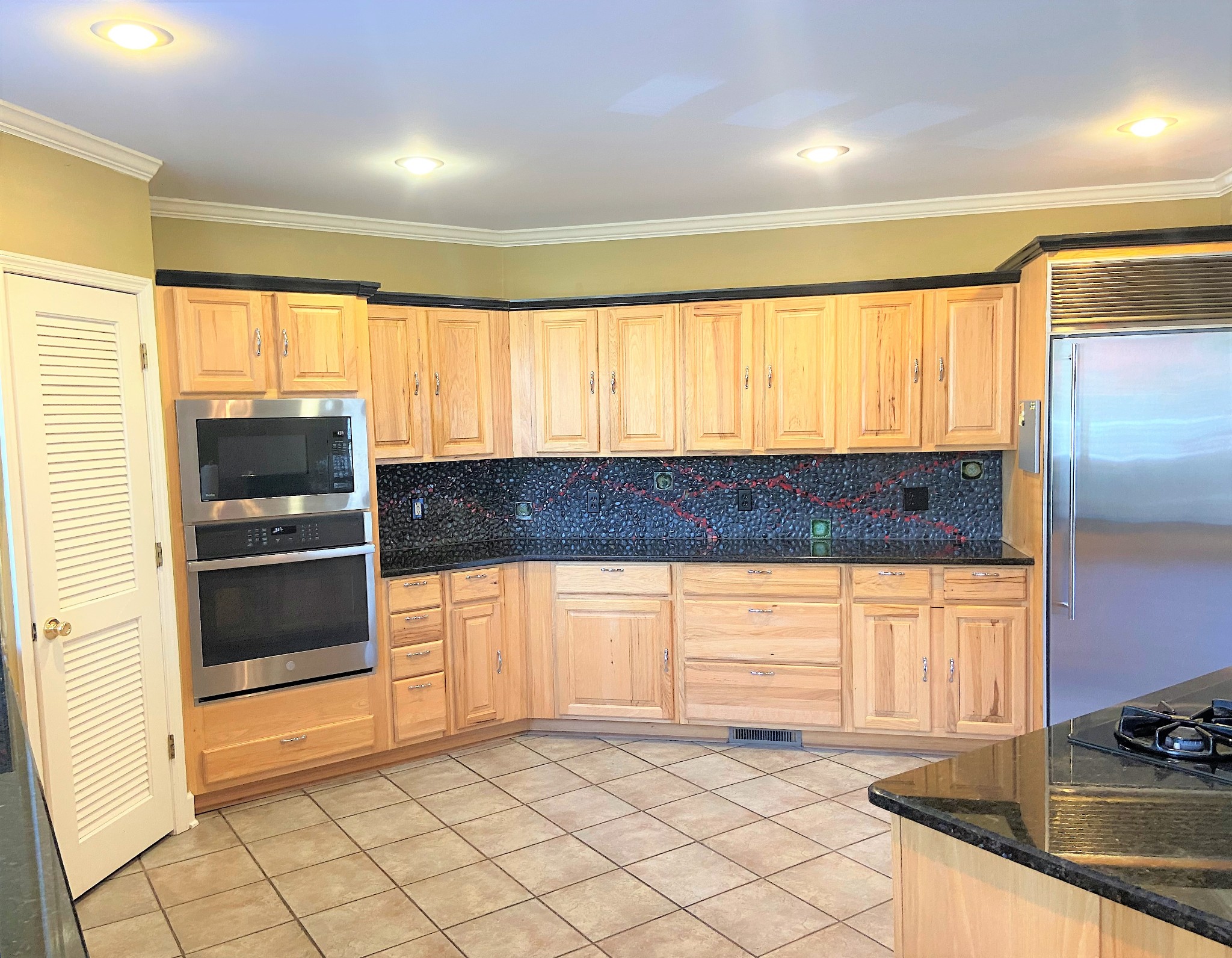 24695 Deer Ridge Lane Athens, AL 35613 - Photo 18 of 49 a kitchen with stainless steel appliances kitchen island granite countertop a refrigerator and a sink