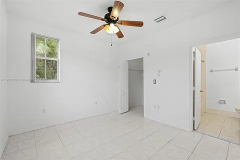 an empty room with closet and windows