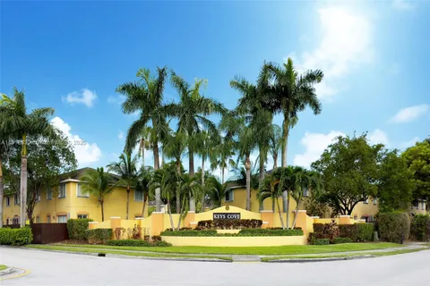 a palm tree sitting in front of a house with a big yard