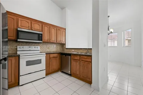 a kitchen with stainless steel appliances granite countertop a stove microwave and cabinets