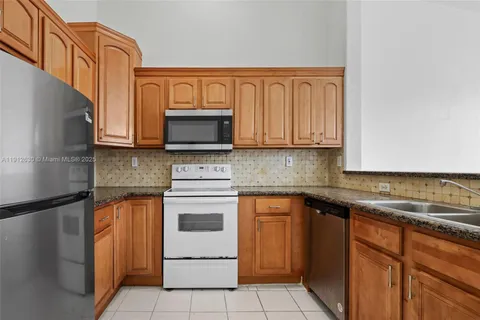 a kitchen with stainless steel appliances granite countertop a sink stove and microwave