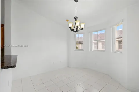 a view of a livingroom with a chandelier fan and windows