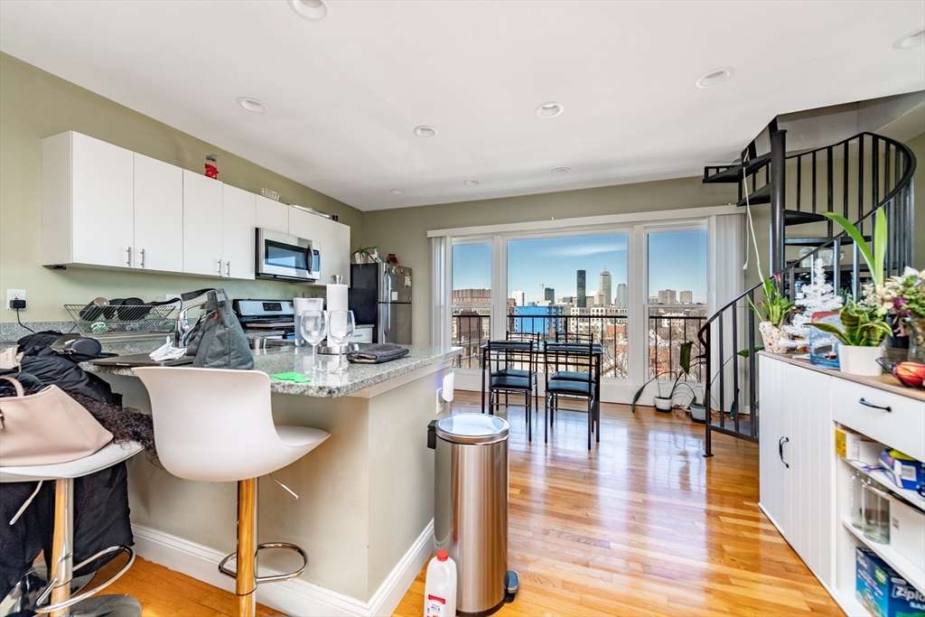 4 Kearsarge Avenue Boston, MA 02119 - Photo 4 of 8 a kitchen with stainless steel appliances granite countertop a table and chairs