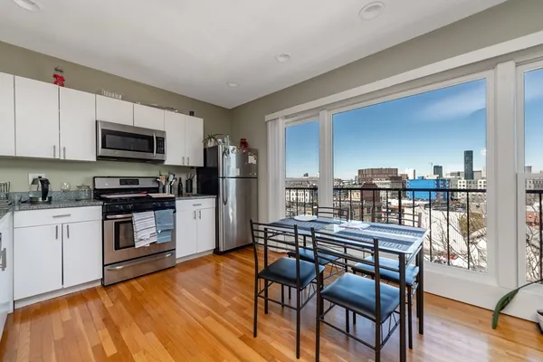 a kitchen with granite countertop wooden floors and wooden cabinets
