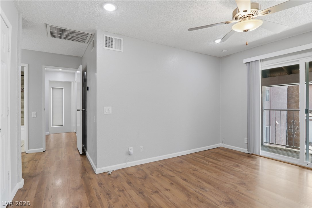 2274 East Desert Inn Road Las Vegas, NV 89169 - Photo 28 of 41 A comfortable bedroom features warm wood flooring and a private balcony entrance.