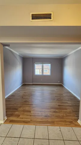 a view of empty room with window and wooden floor