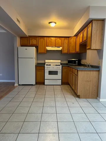 a kitchen with stainless steel appliances granite countertop a stove a refrigerator and a stove top oven