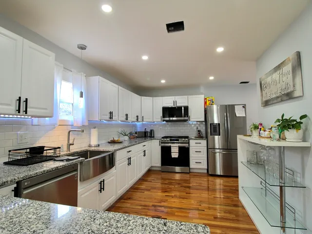 a kitchen with stainless steel appliances granite countertop a sink stove and refrigerator