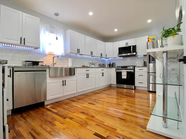 a kitchen with stainless steel appliances granite countertop a stove top oven a sink dishwasher and a refrigerator