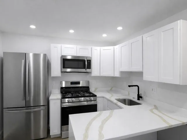 a kitchen with stainless steel appliances a refrigerator a sink a stove a microwave and cabinets