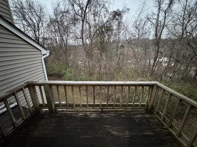 a view of balcony with wooden floor and fence