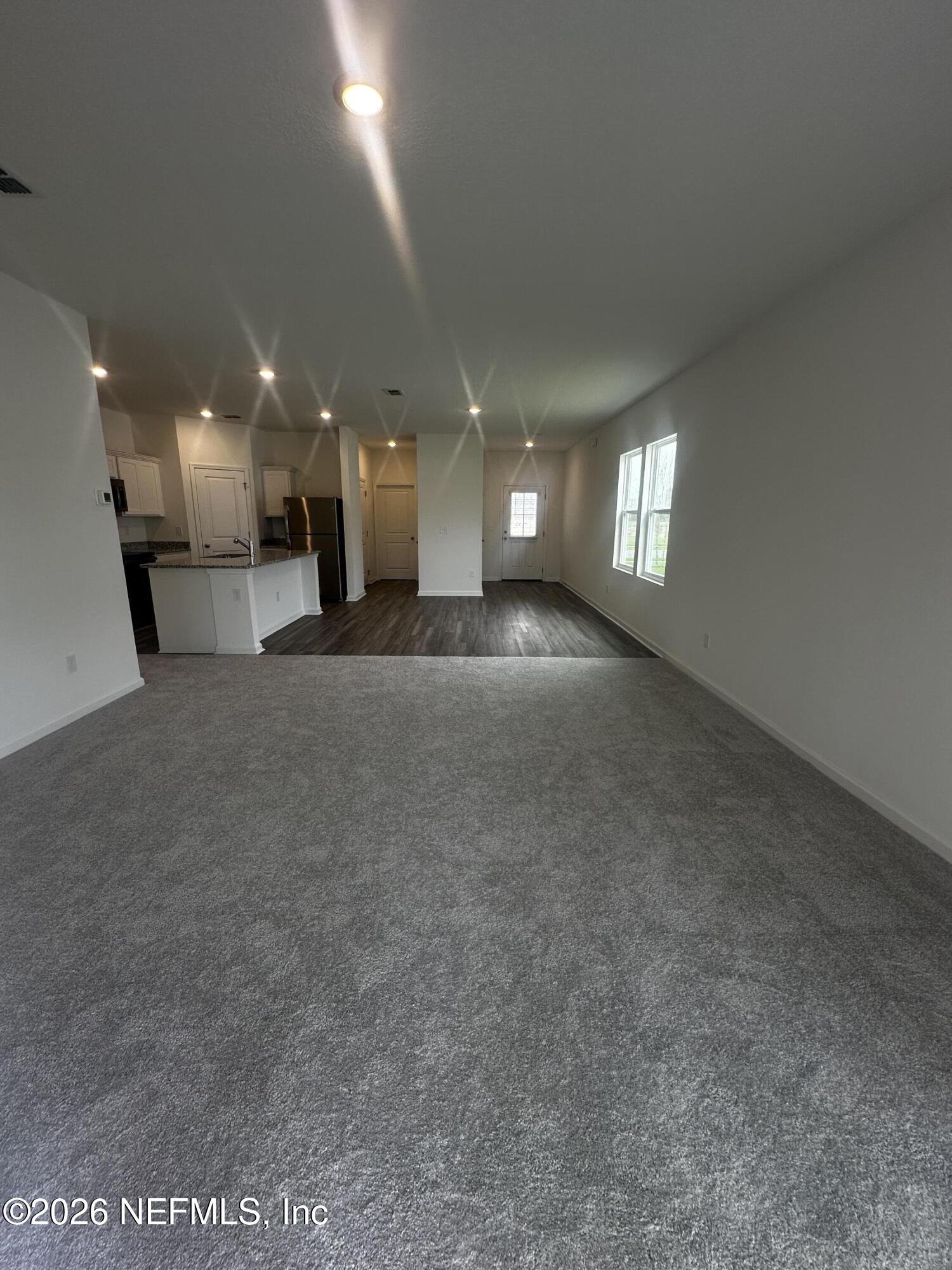54 Oriole Road Palm Coast, FL 32137 - Photo 14 of 23 a view of a big room with windows and chandelier fan