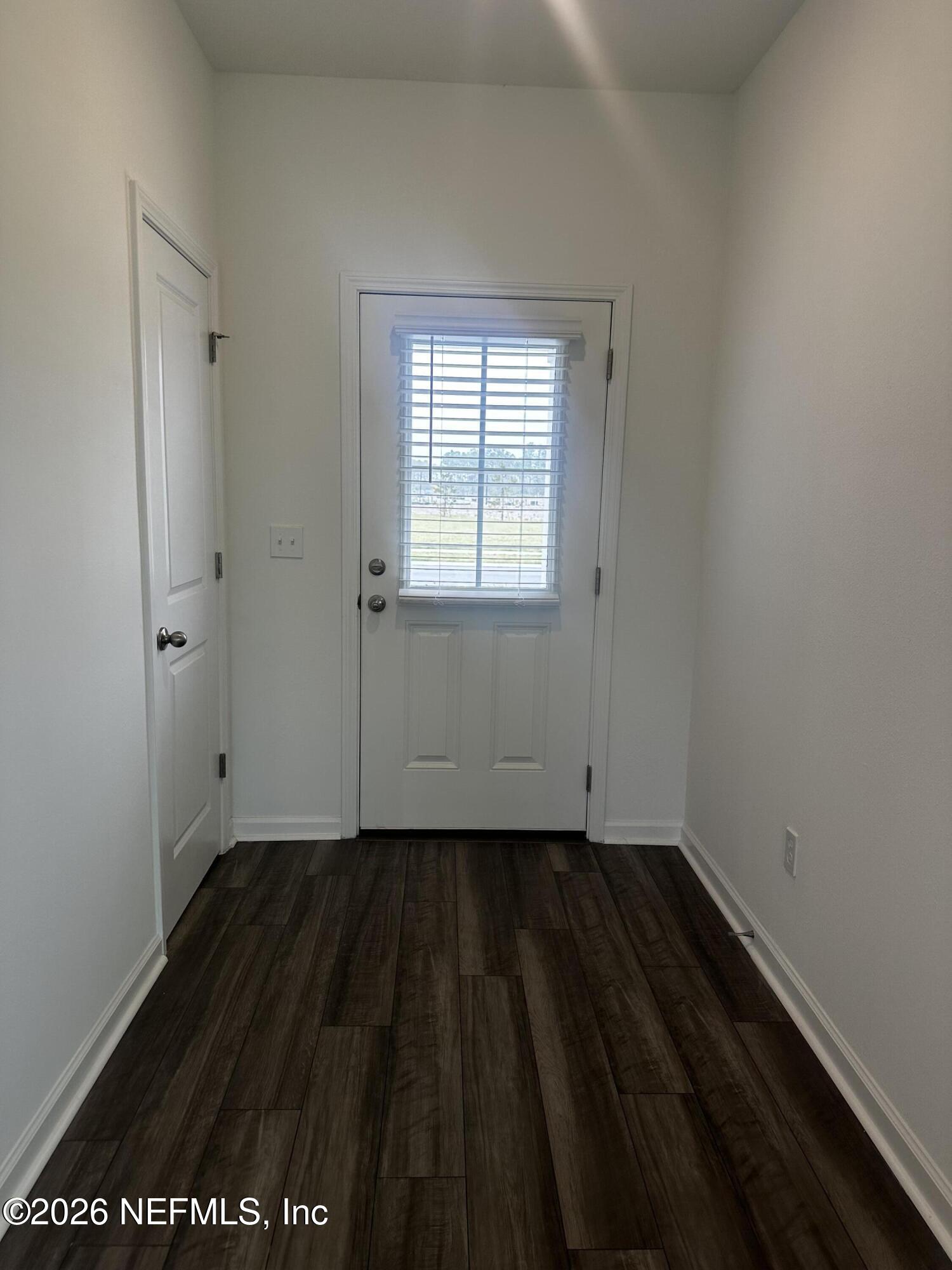 54 Oriole Road Palm Coast, FL 32137 - Photo 2 of 23 a view of an empty room with wooden floor and a window