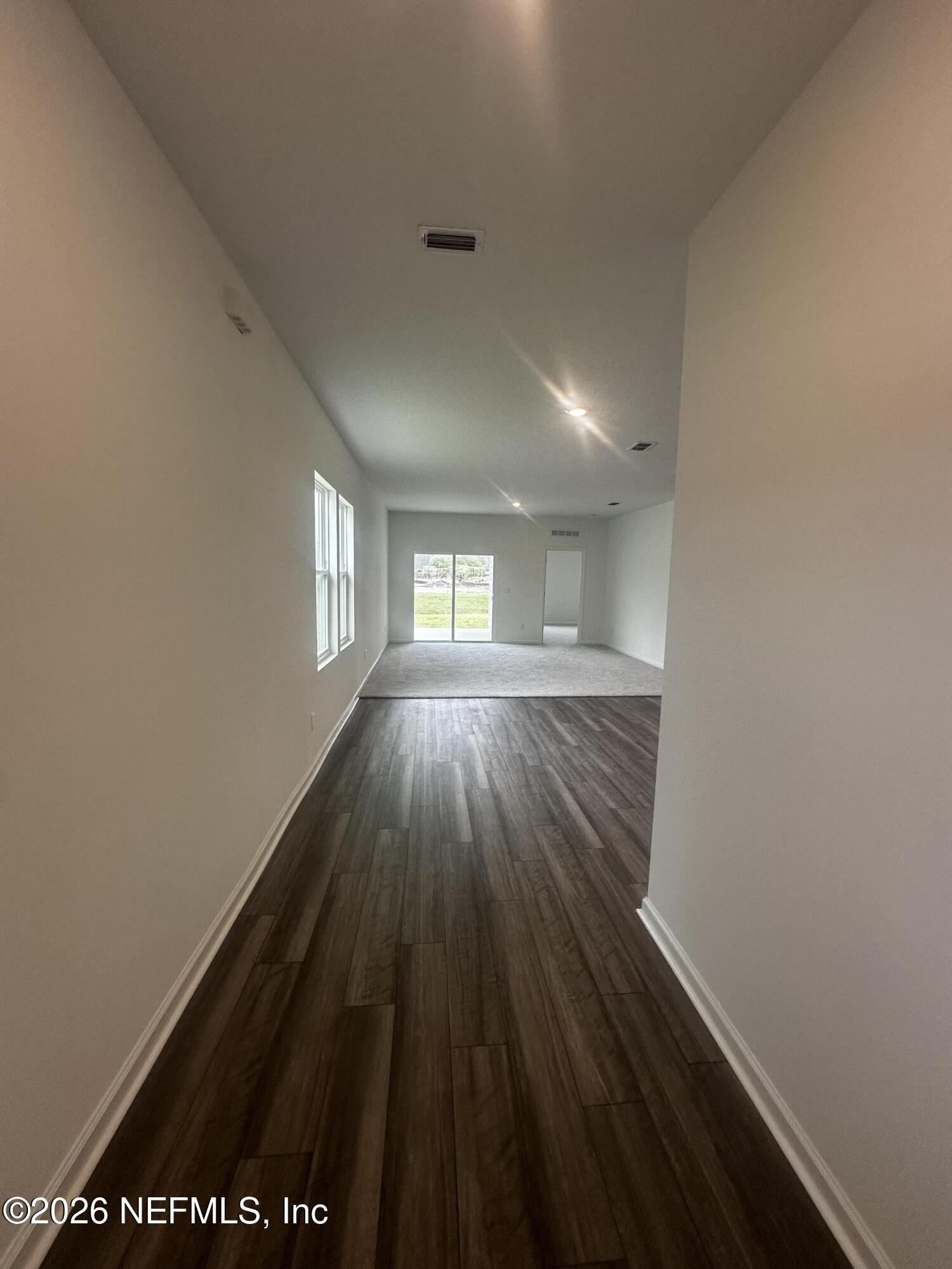 54 Oriole Road Palm Coast, FL 32137 - Photo 3 of 23 wooden floor in an empty room with a window