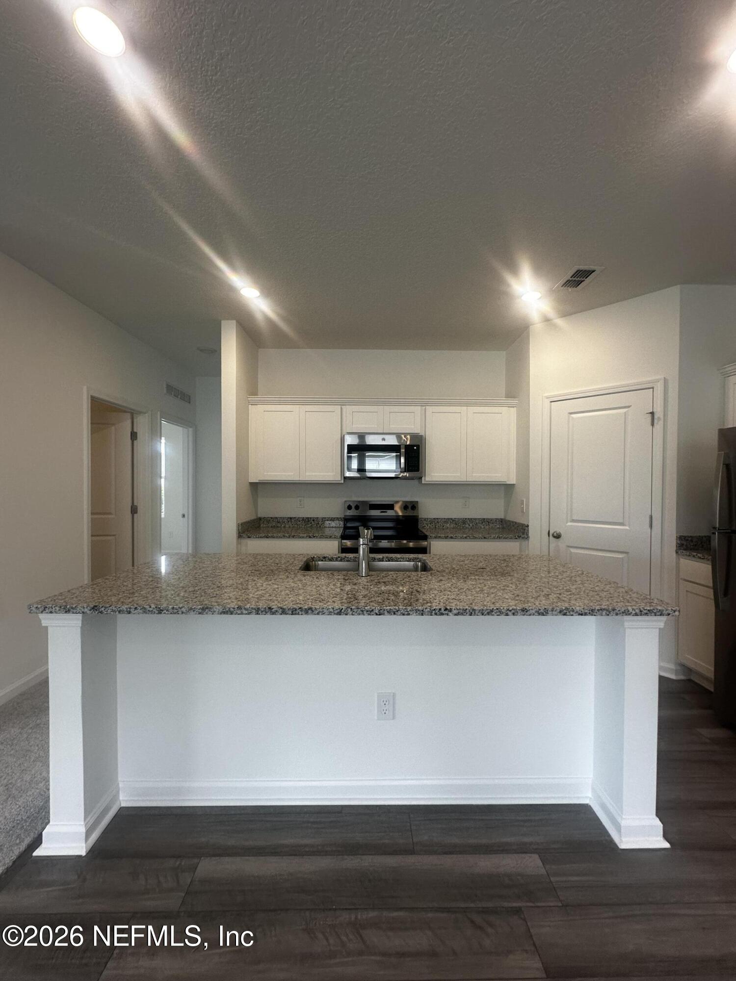 54 Oriole Road Palm Coast, FL 32137 - Photo 5 of 23 a view of a kitchen with kitchen island a sink stainless steel appliances and cabinets