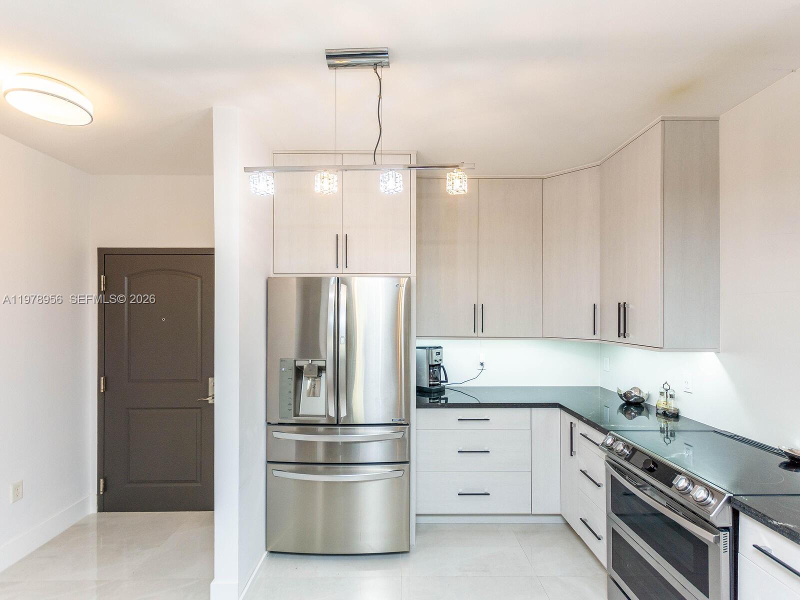 7350 Southwest 89th Street, Unit 719S Miami, FL 33156 - Photo 14 of 30 a kitchen with white cabinets and stainless steel appliances