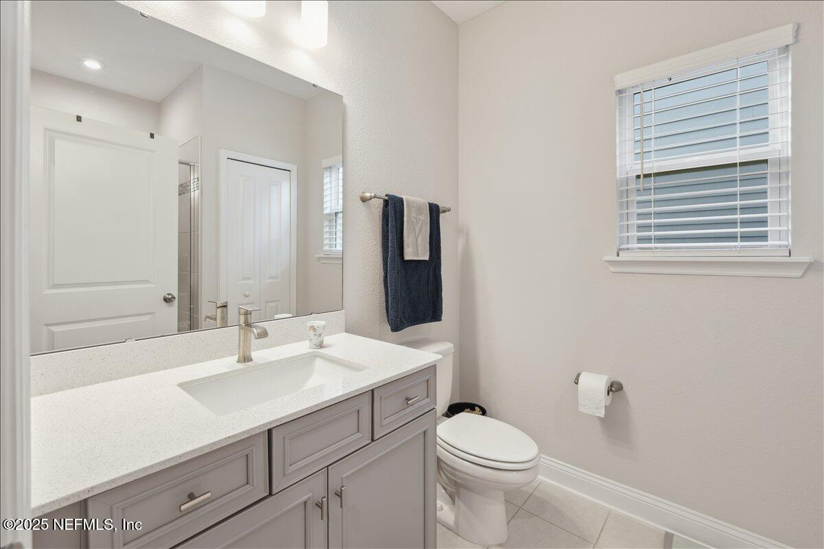 552 Meadow Creek Drive St. Johns, FL 32259 - Photo 13 of 62 a bathroom with a sink a toilet a large mirror and shower