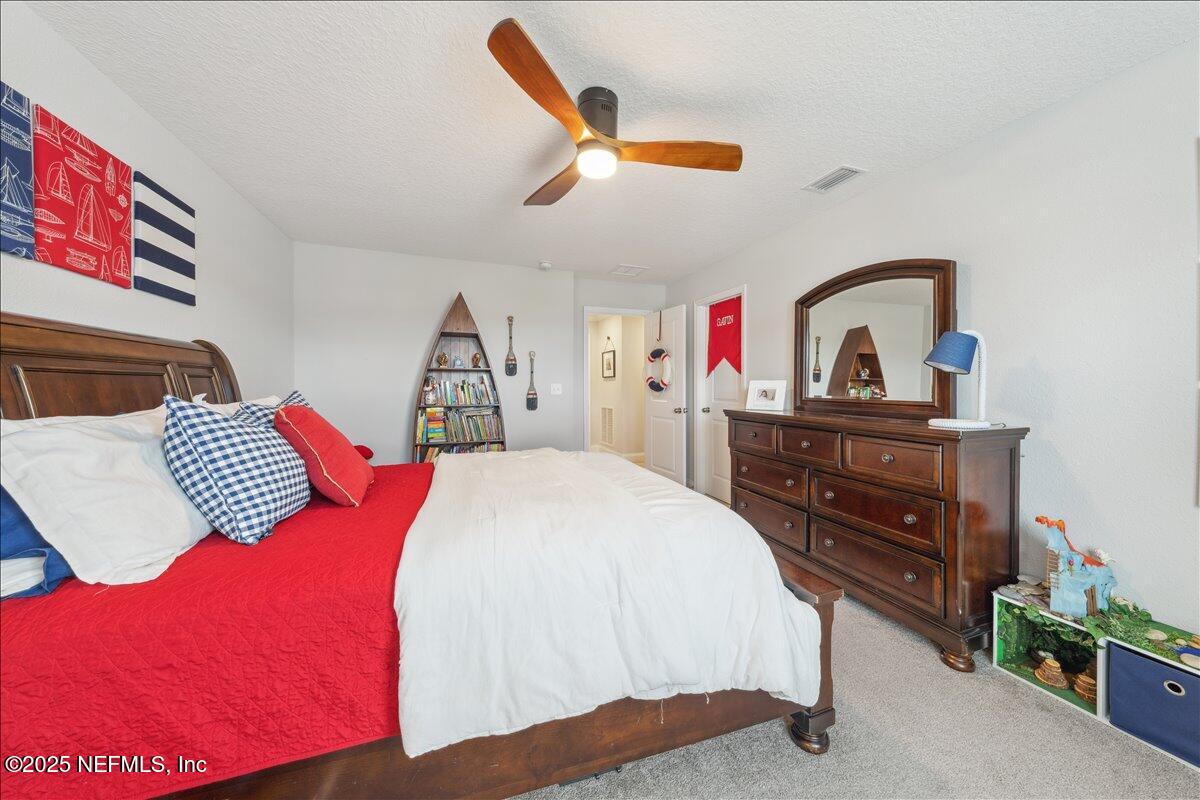 552 Meadow Creek Drive St. Johns, FL 32259 - Photo 18 of 62 a bedroom with a bed and a dresser