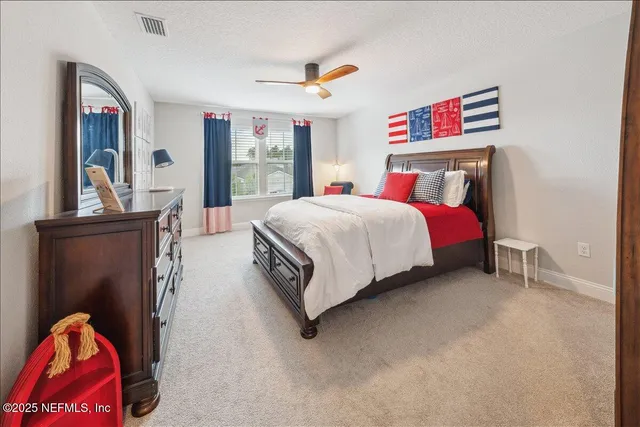 a bedroom with a bed a couch and a flat screen tv