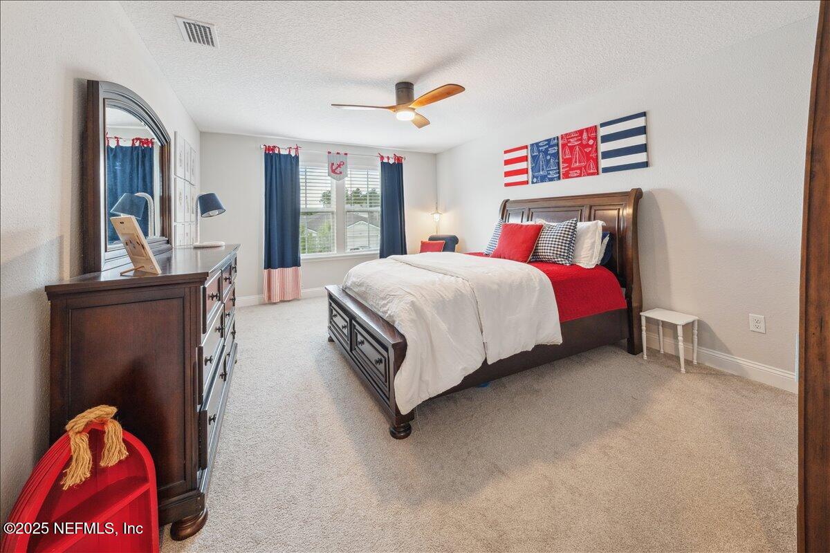 552 Meadow Creek Drive St. Johns, FL 32259 - Photo 19 of 62 a bedroom with a bed and a dresser