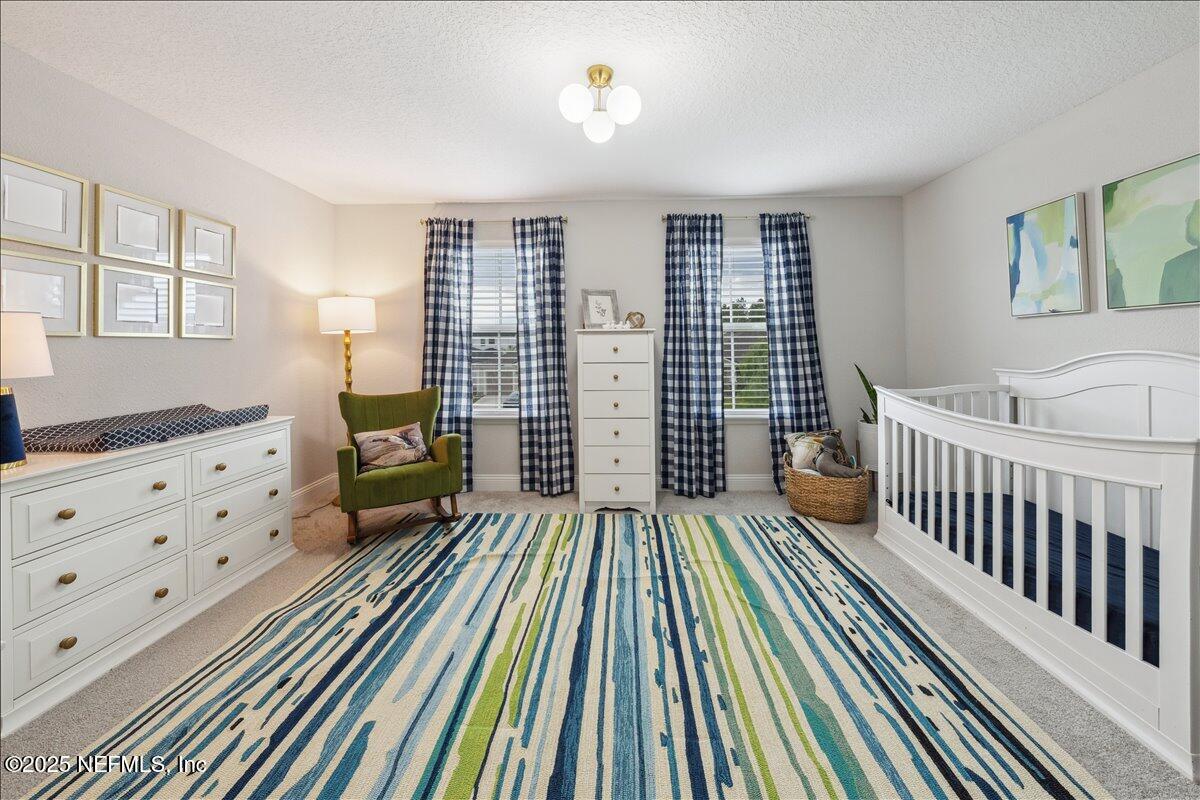 552 Meadow Creek Drive St. Johns, FL 32259 - Photo 20 of 62 a view of a bedroom with furniture and windows
