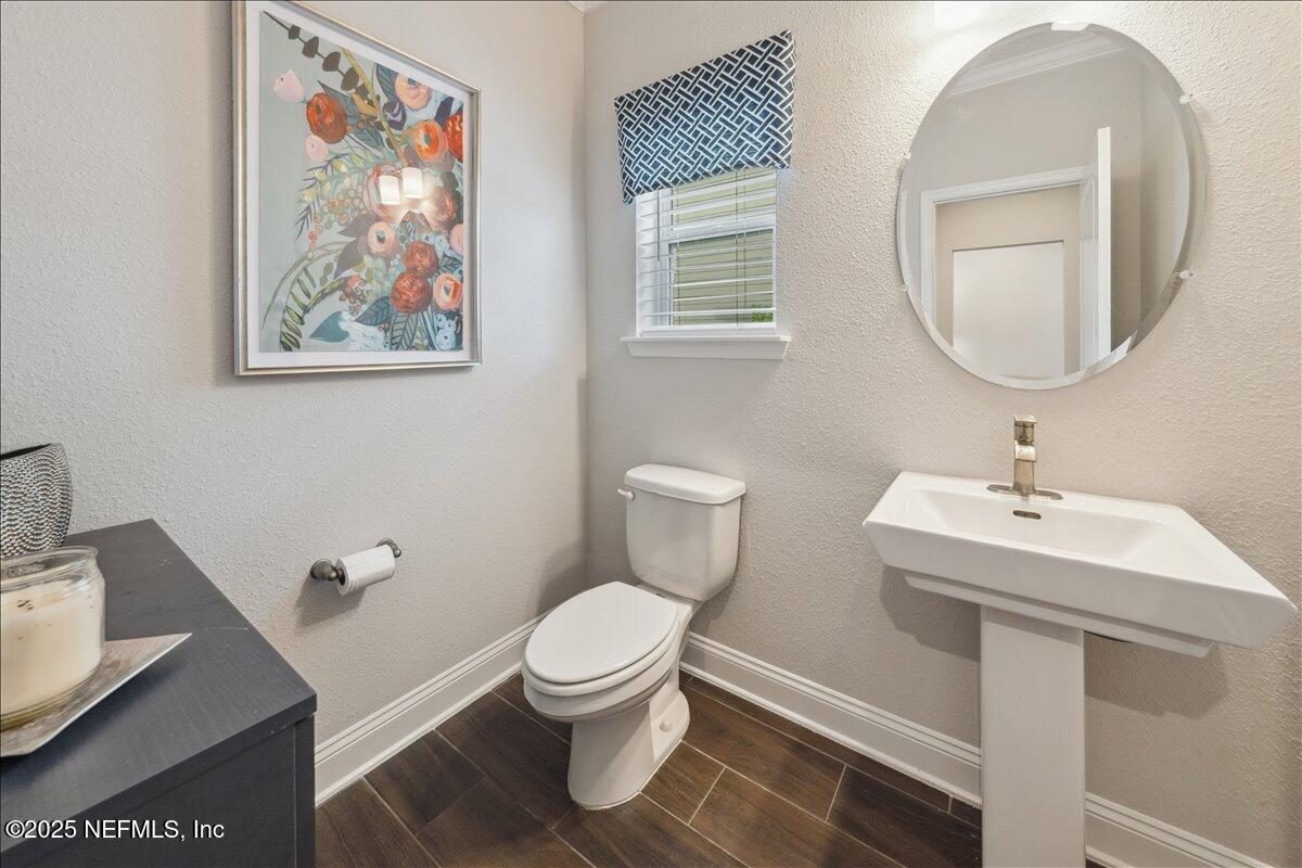 552 Meadow Creek Drive St. Johns, FL 32259 - Photo 24 of 62 a bathroom with a toilet a sink and mirror