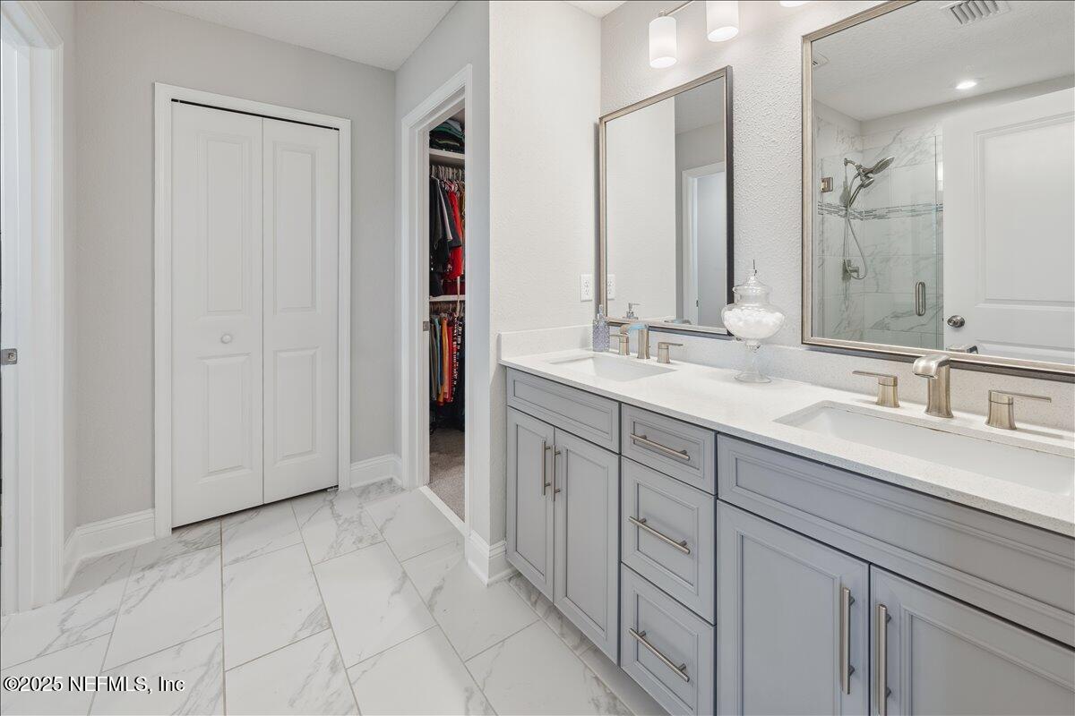 552 Meadow Creek Drive St. Johns, FL 32259 - Photo 26 of 62 a spacious bathroom with a double vanity sink a mirror and a shower