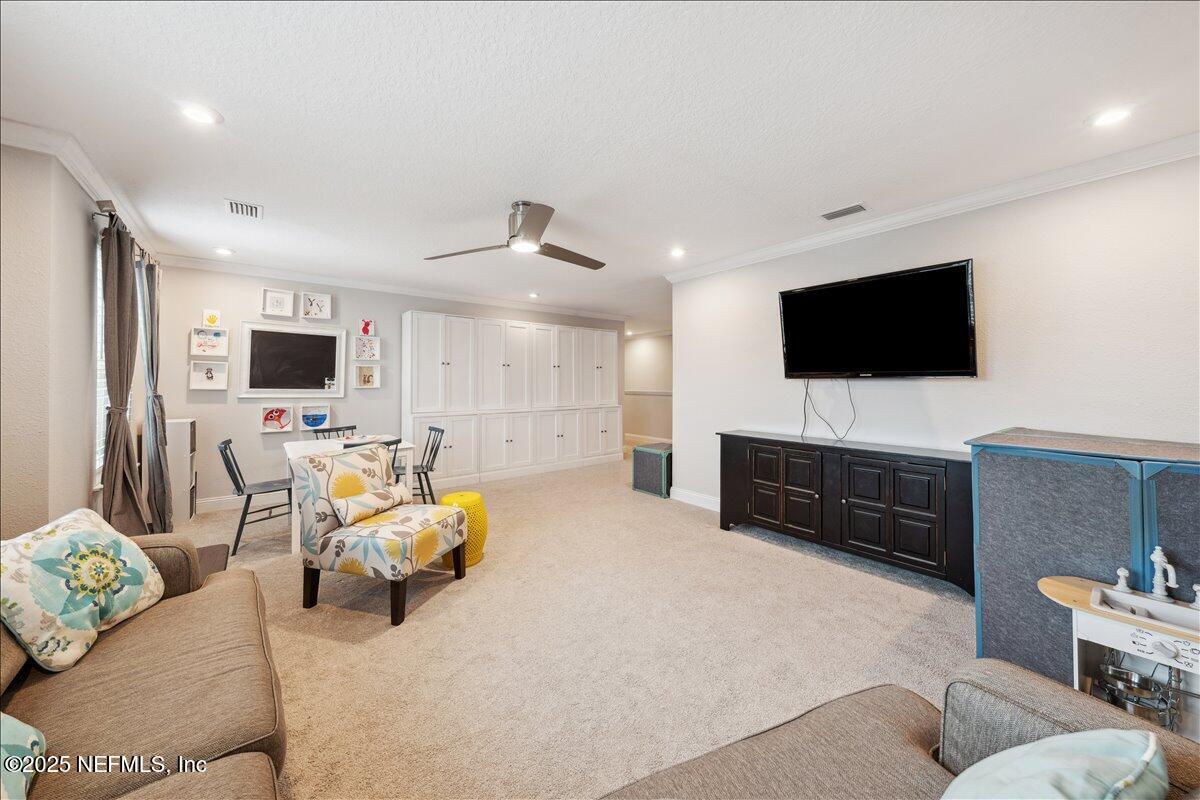 552 Meadow Creek Drive St. Johns, FL 32259 - Photo 31 of 62 a living room with furniture and a flat screen tv