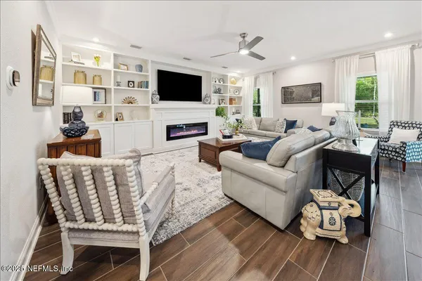 a living room with furniture a flat screen tv and a fireplace