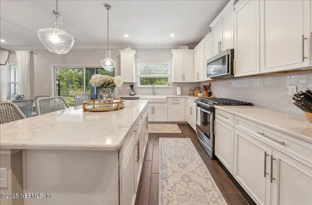 a kitchen with sink a stove and cabinets