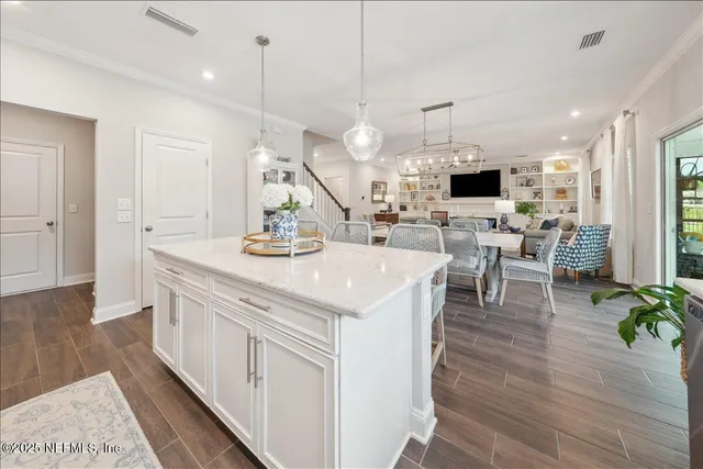 a view of living room with kitchen island furniture and a flat screen tv