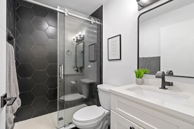 a bathroom with a sink a toilet and shower