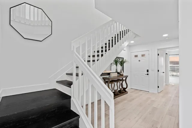 a view of staircase with railing and white walls