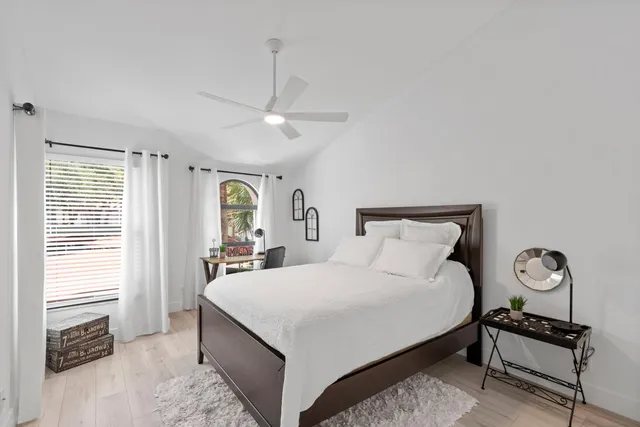a bedroom with a large bed and a chandelier